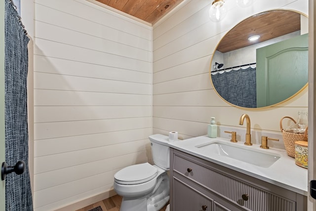 bathroom featuring wood walls, vanity, toilet, and wooden ceiling