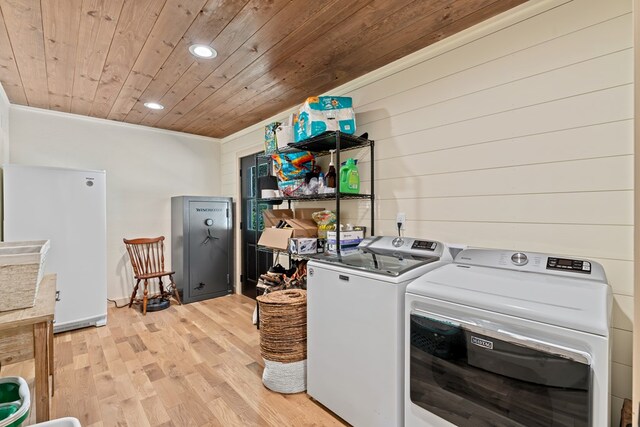 clothes washing area with wood ceiling, washer and dryer, light wood-type flooring, and crown molding