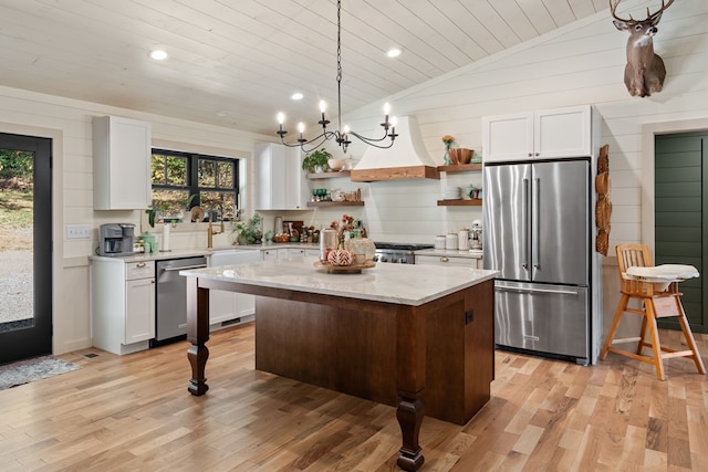 kitchen featuring light hardwood / wood-style floors, a center island, stainless steel appliances, and vaulted ceiling