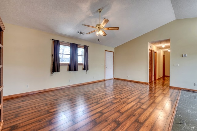 spare room featuring a textured ceiling, lofted ceiling, ceiling fan, and dark hardwood / wood-style floors