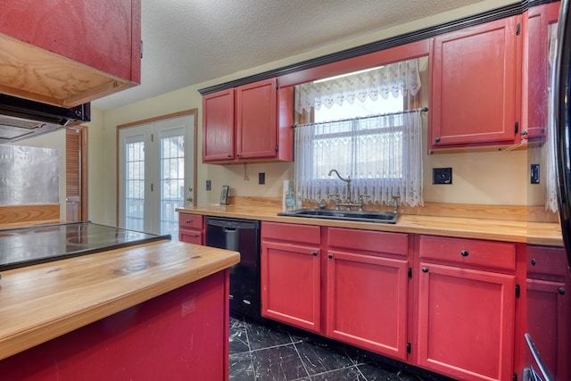 kitchen featuring wooden counters, sink, black appliances, and a textured ceiling