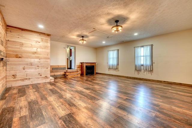 unfurnished living room with dark wood-type flooring and a textured ceiling