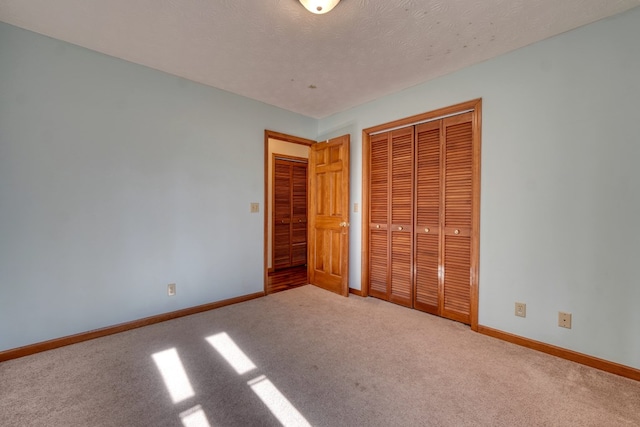 unfurnished bedroom featuring a closet, carpet floors, and a textured ceiling