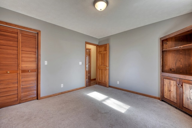 unfurnished bedroom featuring a textured ceiling, light carpet, and a closet