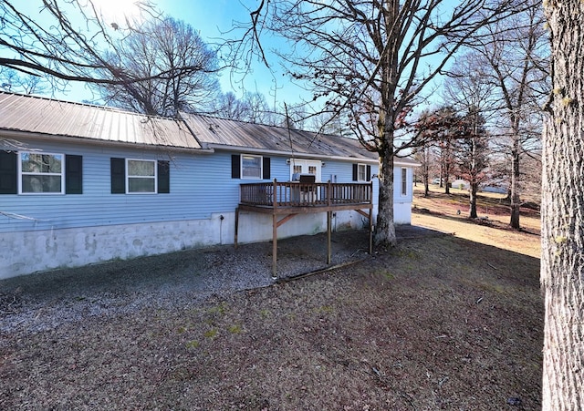 rear view of property featuring a deck