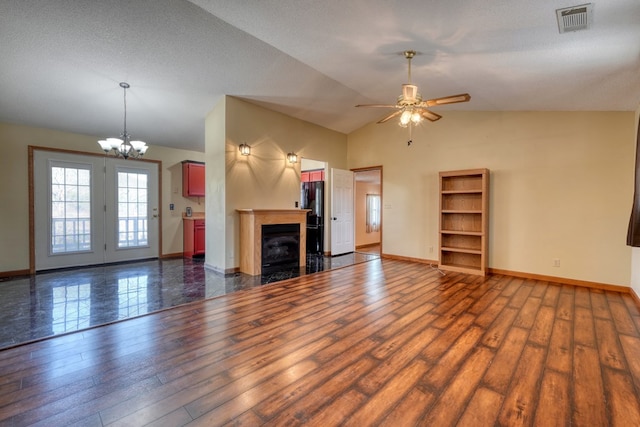 unfurnished living room featuring a textured ceiling, lofted ceiling, dark hardwood / wood-style flooring, and ceiling fan with notable chandelier