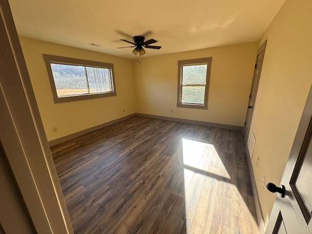 unfurnished room with ceiling fan and dark wood-type flooring