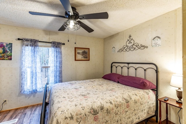 bedroom featuring wood-type flooring, multiple windows, and a textured ceiling