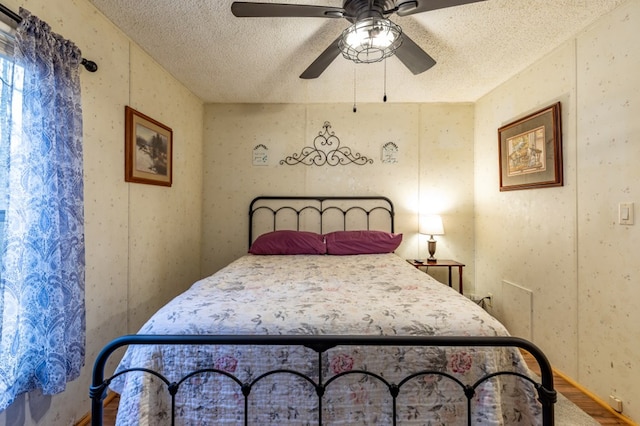 bedroom with ceiling fan and a textured ceiling