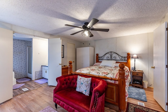 bedroom with ceiling fan, light hardwood / wood-style flooring, and a textured ceiling