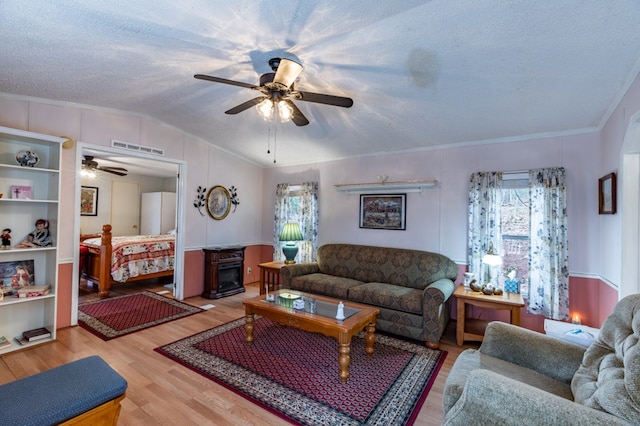 living room with lofted ceiling, light hardwood / wood-style flooring, a textured ceiling, and plenty of natural light