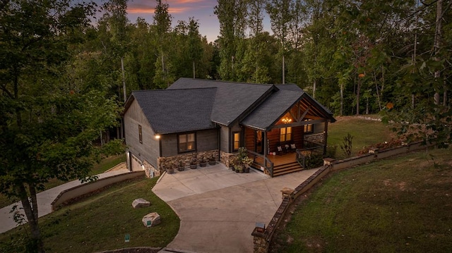 view of front of home with a garage, a yard, and a porch