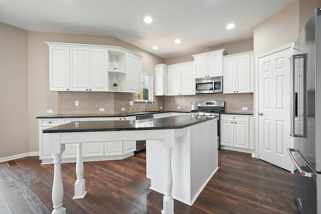 6665 Flagstone Ct, Cumming, GA 30028 - kitchen with appliances with stainless steel finishes, a kitchen island, white cabinetry, open shelves, and dark wood-type flooring
