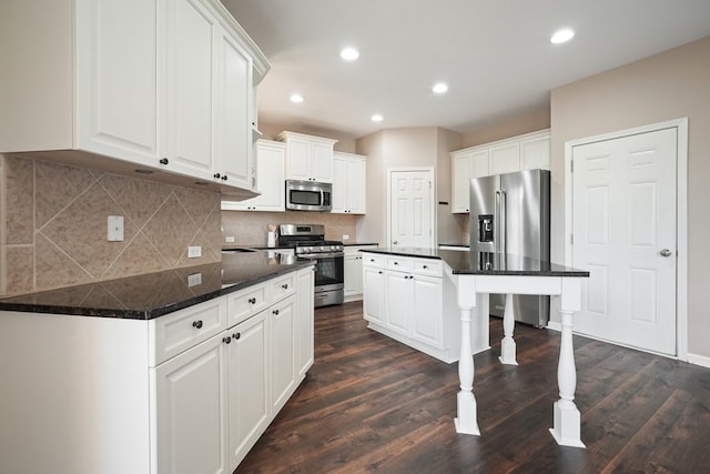 6665 Flagstone Ct, Cumming, GA 30028 - kitchen with stainless steel appliances, white cabinets, dark wood-style floors, dark countertops, and recessed lighting