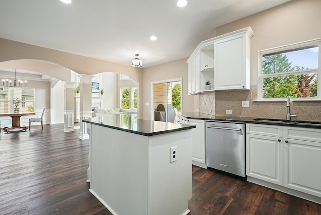 6665 Flagstone Ct, Cumming, GA 30028 - kitchen featuring stainless steel dishwasher, dark countertops, ornate columns, open shelves, and a kitchen island