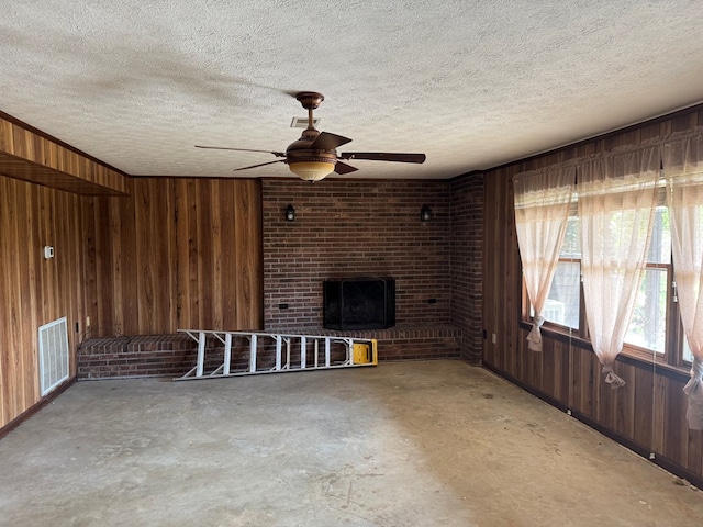558 Old Dyer Rd, Hayesville, NC 28904 - unfurnished living room featuring a textured ceiling, concrete floors, a ceiling fan, visible vents, and wood walls
