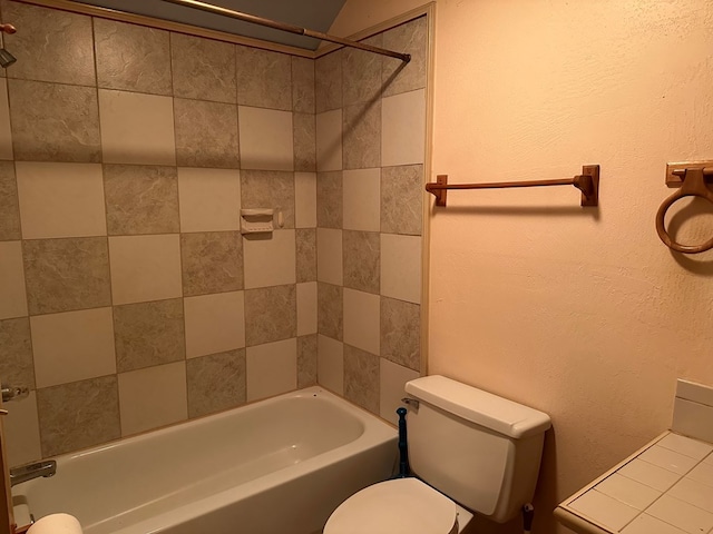 bathroom featuring tiled shower / bath and toilet