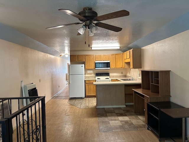 kitchen with light wood-type flooring, white appliances, ceiling fan, and a textured ceiling