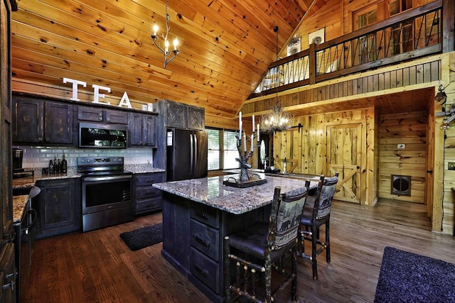 162 Grayson Pt, Blue Ridge, GA 30513 - kitchen with stainless steel appliances, dark wood-type flooring, a chandelier, wood walls, and decorative backsplash