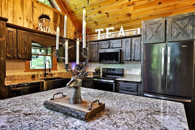 162 Grayson Pt, Blue Ridge, GA 30513 - kitchen featuring appliances with stainless steel finishes, lofted ceiling, tasteful backsplash, a sink, and light stone counters