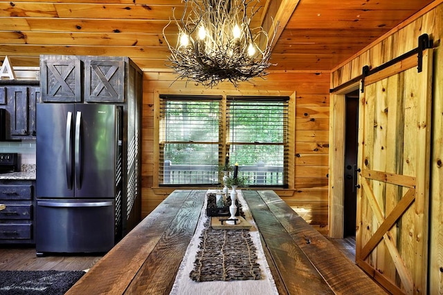 162 Grayson Pt, Blue Ridge, GA 30513 - kitchen with freestanding refrigerator, a barn door, wooden walls, wood finished floors, and a chandelier