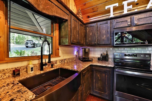 162 Grayson Pt, Blue Ridge, GA 30513 - kitchen featuring stainless steel appliances, a sink, light stone countertops, dark brown cabinetry, and decorative backsplash