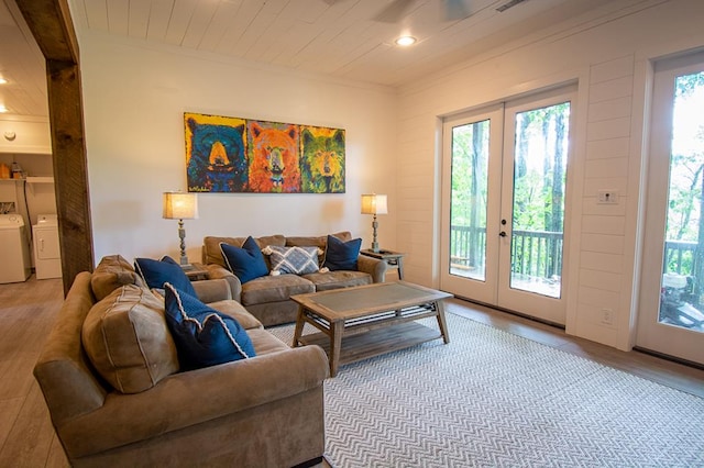 living room featuring french doors, light hardwood / wood-style floors, and washing machine and dryer