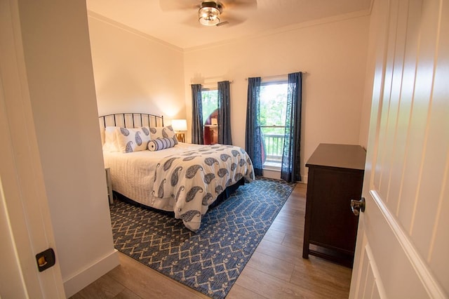 bedroom featuring hardwood / wood-style floors, ceiling fan, and crown molding