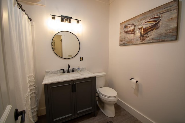 bathroom featuring toilet, vanity, hardwood / wood-style floors, and curtained shower