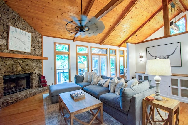 living room featuring beam ceiling, wood ceiling, hardwood / wood-style flooring, and a fireplace