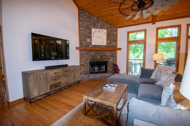 living room featuring ceiling fan, high vaulted ceiling, wood-type flooring, wood ceiling, and a stone fireplace