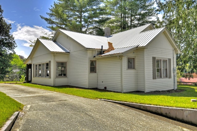 102 Riverview St, Copperhill, TN 37317 - back of property with a standing seam roof, a chimney, a lawn, and metal roof