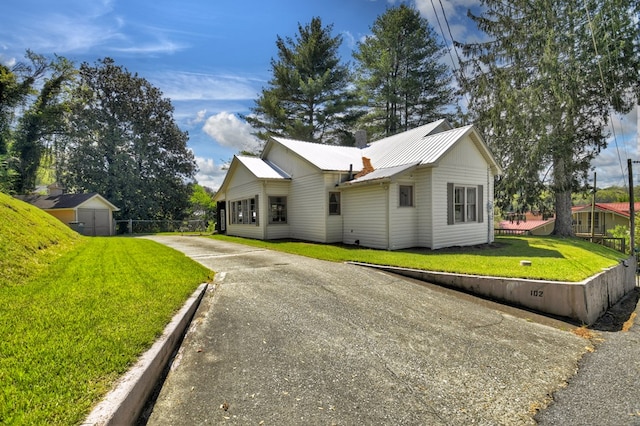 102 Riverview St, Copperhill, TN 37317 - view of side of home with a lawn, a storage unit, metal roof, and a chimney
