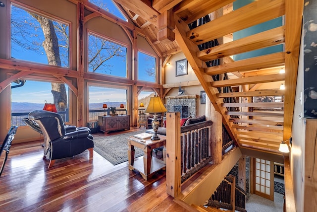 living room featuring a mountain view, a fireplace, wood-type flooring, and a high ceiling