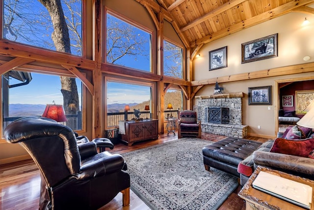 living room with wooden ceiling, hardwood / wood-style flooring, high vaulted ceiling, and a stone fireplace