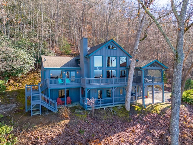 back of house with a deck, a patio area, and a sunroom