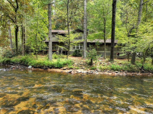 view of yard featuring a sunroom and a water view