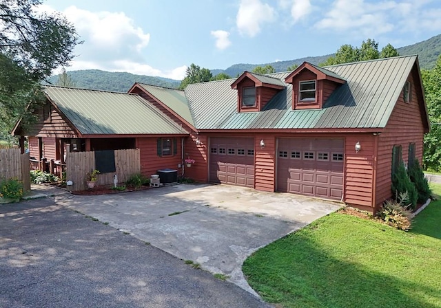 log cabin featuring central AC, a mountain view, a front lawn, and a garage