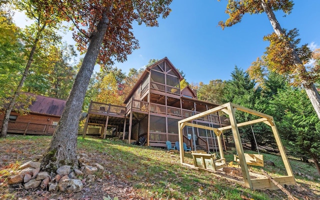 back of house featuring a wooden deck and a sunroom