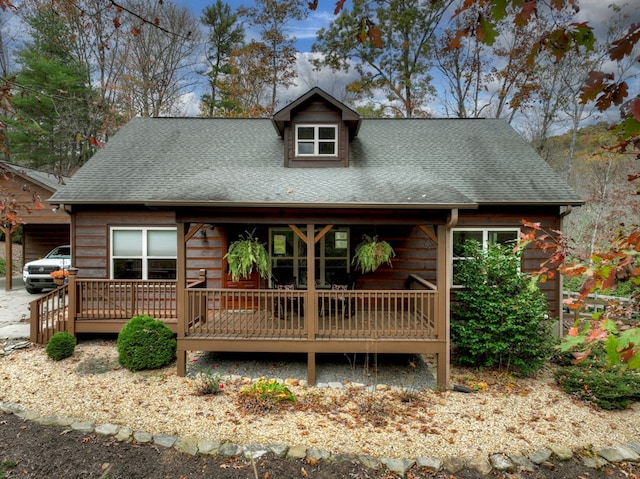 view of front of property with a deck and a shingled roof