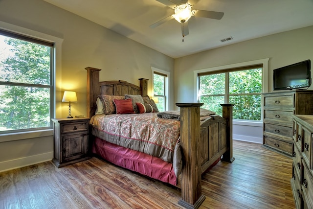 bedroom featuring visible vents, ceiling fan, baseboards, and wood finished floors