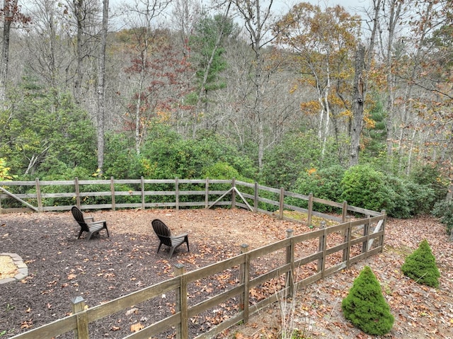 view of yard with fence and a view of trees