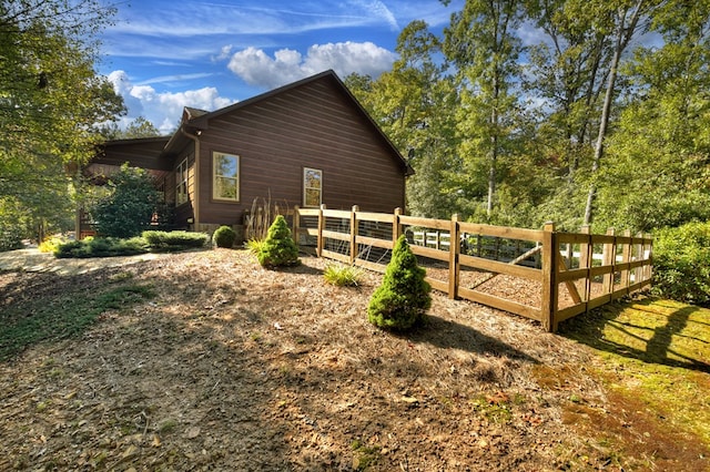 view of side of home featuring fence