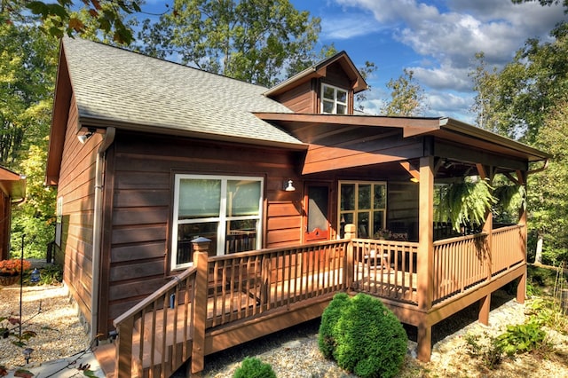 rear view of house with a deck and a shingled roof