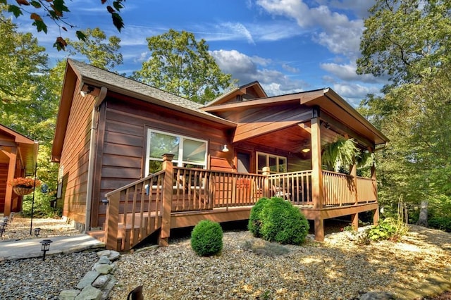 exterior space featuring a shingled roof and a wooden deck