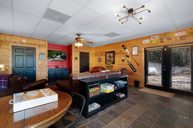 327 Dancing Trees Trl, Morganton, GA 30560 - living area with wooden walls, a drop ceiling, a ceiling fan, a chandelier, and stone finish floors