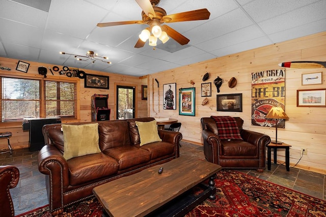 327 Dancing Trees Trl, Morganton, GA 30560 - living area with stone tile flooring, wooden walls, a drop ceiling, and a ceiling fan