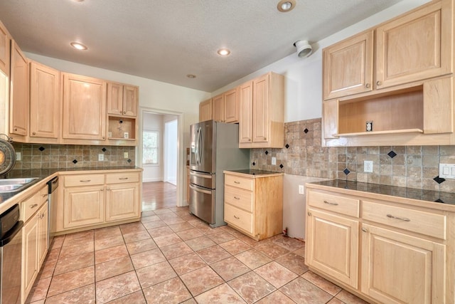 kitchen with light brown cabinetry, backsplash, open shelves, and appliances with stainless steel finishes