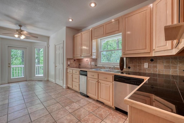 kitchen with a sink, light tile patterned floors, dishwasher, and light brown cabinetry