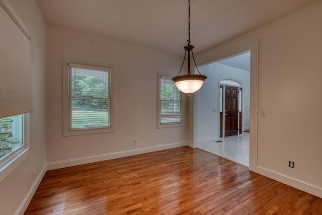 unfurnished room with baseboards and light wood finished floors